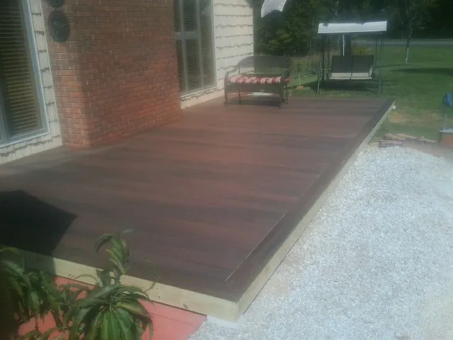 Freshly stained wood deck built against a brick home in Canterbury